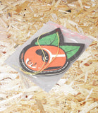 Car air freshener with cherry design on a bed of wood shavings