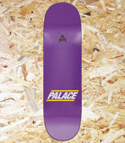 A purple Palace skateboard deck with the brand logo printed in white and yellow, displayed vertically on a background of shredded particle board.