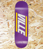 A purple skateboard deck with a bold white and yellow 'VILLE' graphic, shown flat against a background of shredded orange-brown wood chips.